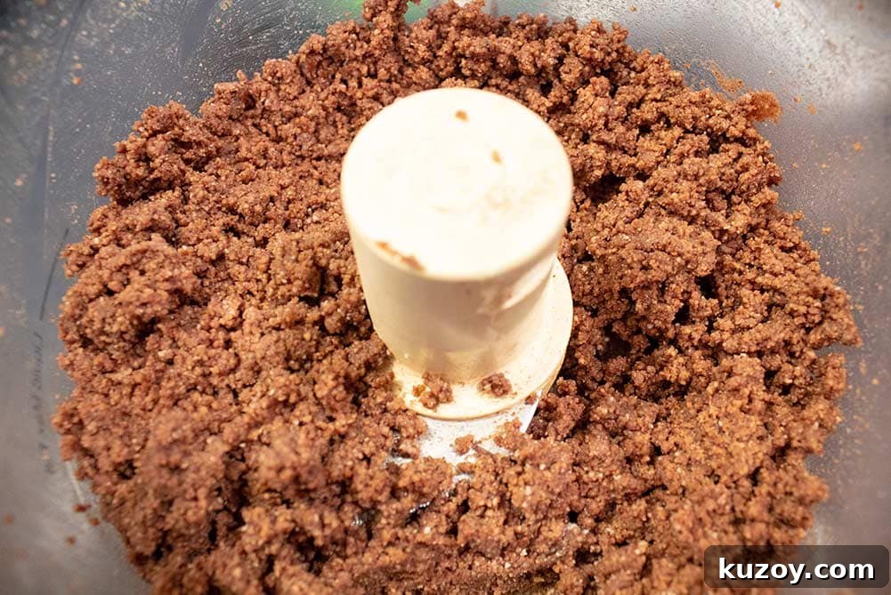 Caffeinated Keto Chocolate Coffee Fat Bombs for Energy 5 keto chocolate mixed with pecans processed in the inside of a food processor