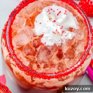 Swig Spring Fling Copycat Drink Recipe for Valentine’s Day 7 Strawberry dirty Dr Pepper drink with pebble ice and whipped cream, garnished with red sugar rim and surrounded by fresh strawberries.