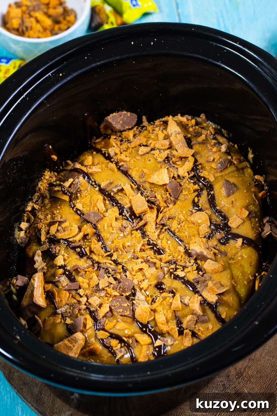Slow Cooker Butterfinger Cake Recipe for Gooey Chocolate-Peanut Butter Delight 4 Frosted cake in slow cooker.