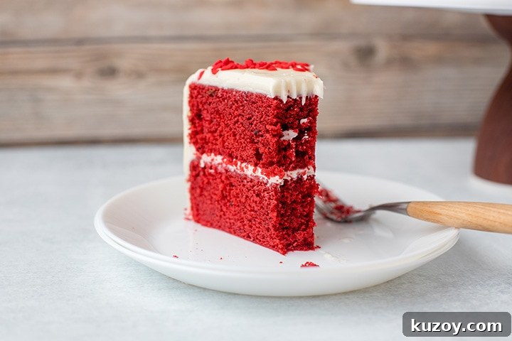 One-Bowl Red Velvet Layer Cake Recipe for Moist Layers 5 A slice of red velvet cake with cream cheese frosting.