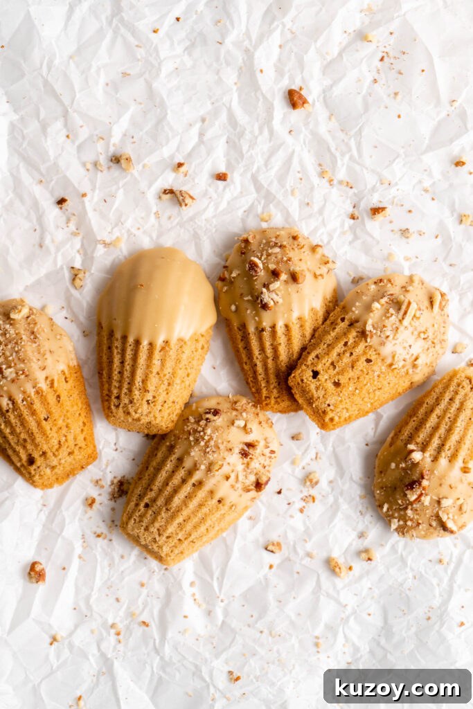 Maple Chai Madeleines Recipe: Spiced Tea-Infused French Cookies 2 maple chai spiced madeleines dipped in a maple glaze and sprinkled with crushed pecans