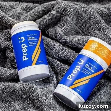 Two Prep U Citrus Mint natural deodorant sticks are laying on a grey towel. One of the sticks is open without a top.