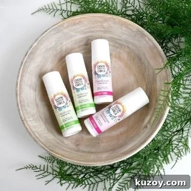 A flat lay of a bowl with fern-like greenery wrapped around. Inside the bowl are four sticks of plant-based deodorant from Good for You Girls.