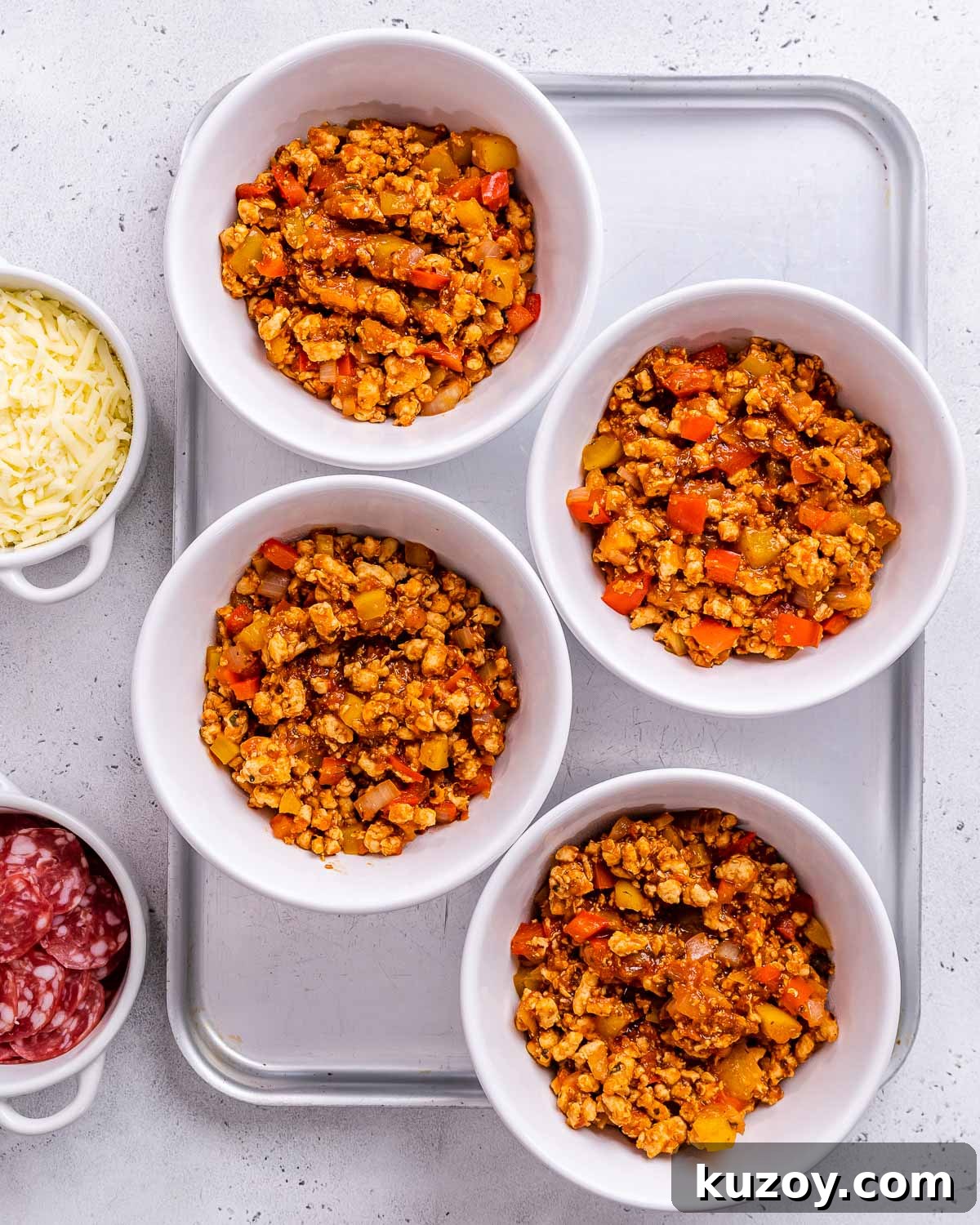 High-Protein Keto Pizza Bowls — Low-Carb Meal Prep 7 Skillet ingredients divided into bowls to make crustless pizza bowls.
