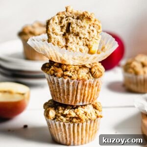 Cinnamon Apple Oat Crumble Muffins 15 Stack of three apple crumble muffins. The top has a bite removed.