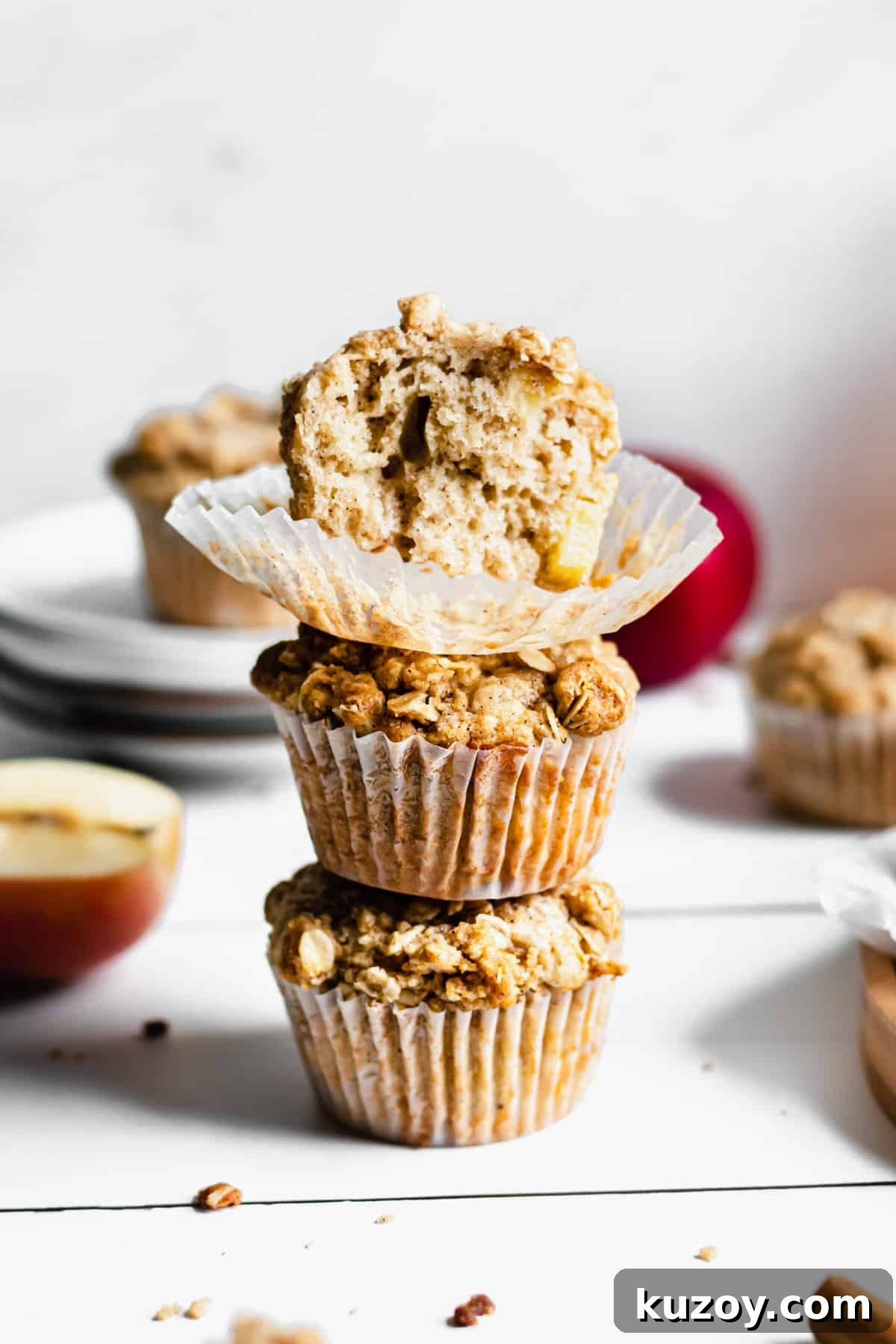 Cinnamon Apple Oat Crumble Muffins 3 stack of three apple streusel muffins. the top muffin has a bite removed