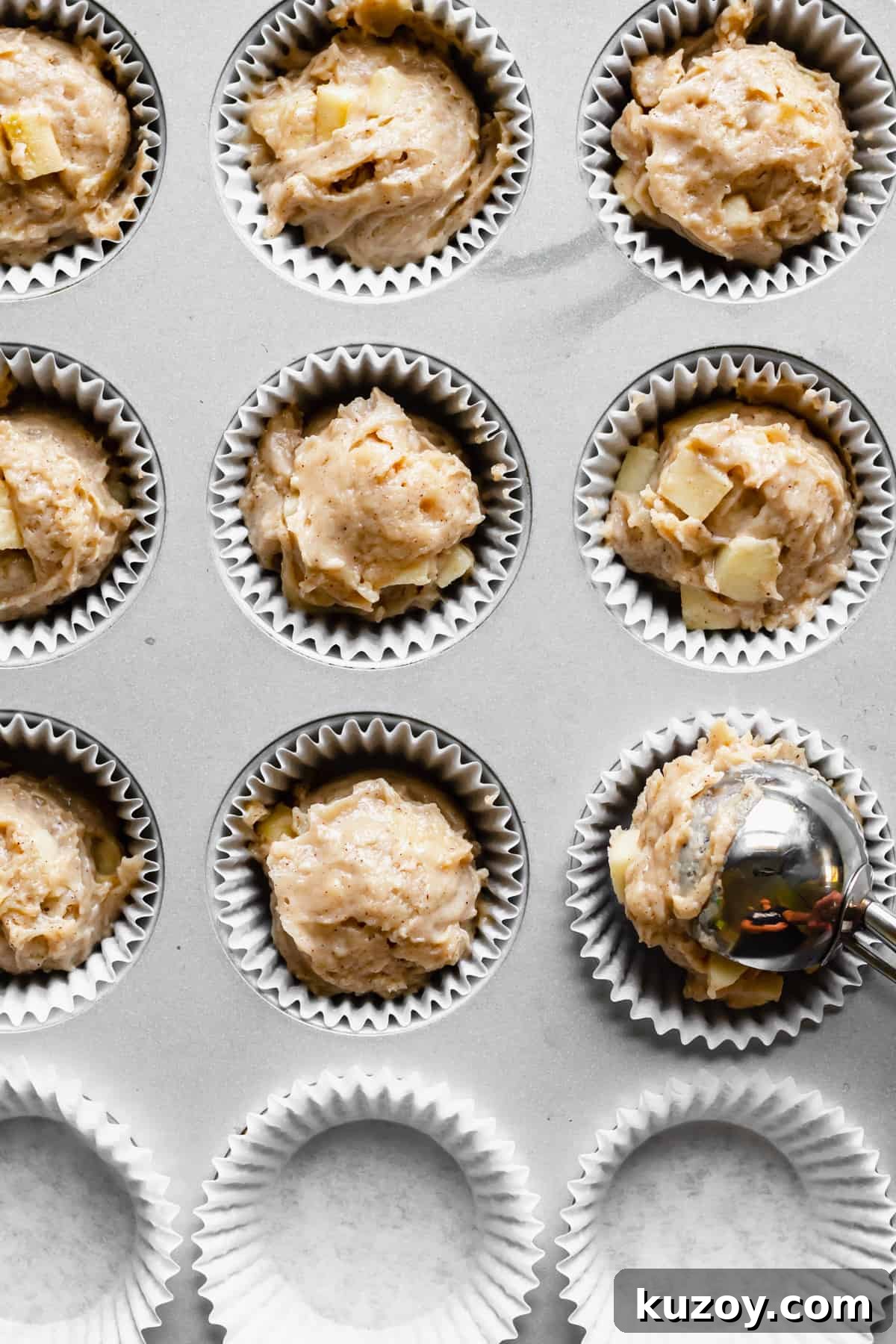 Cinnamon Apple Oat Crumble Muffins 8 Batter being added to muffin tins with a large cookie scoop.
