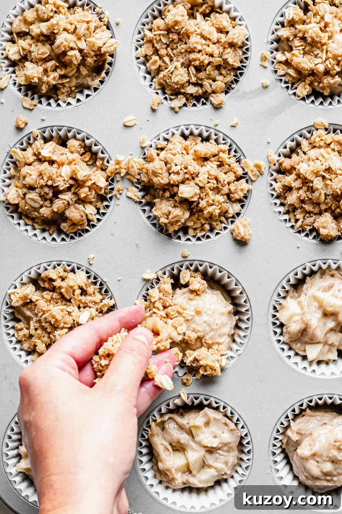 Cinnamon Apple Oat Crumble Muffins 9 Crumble topping being added to the muffin wells.