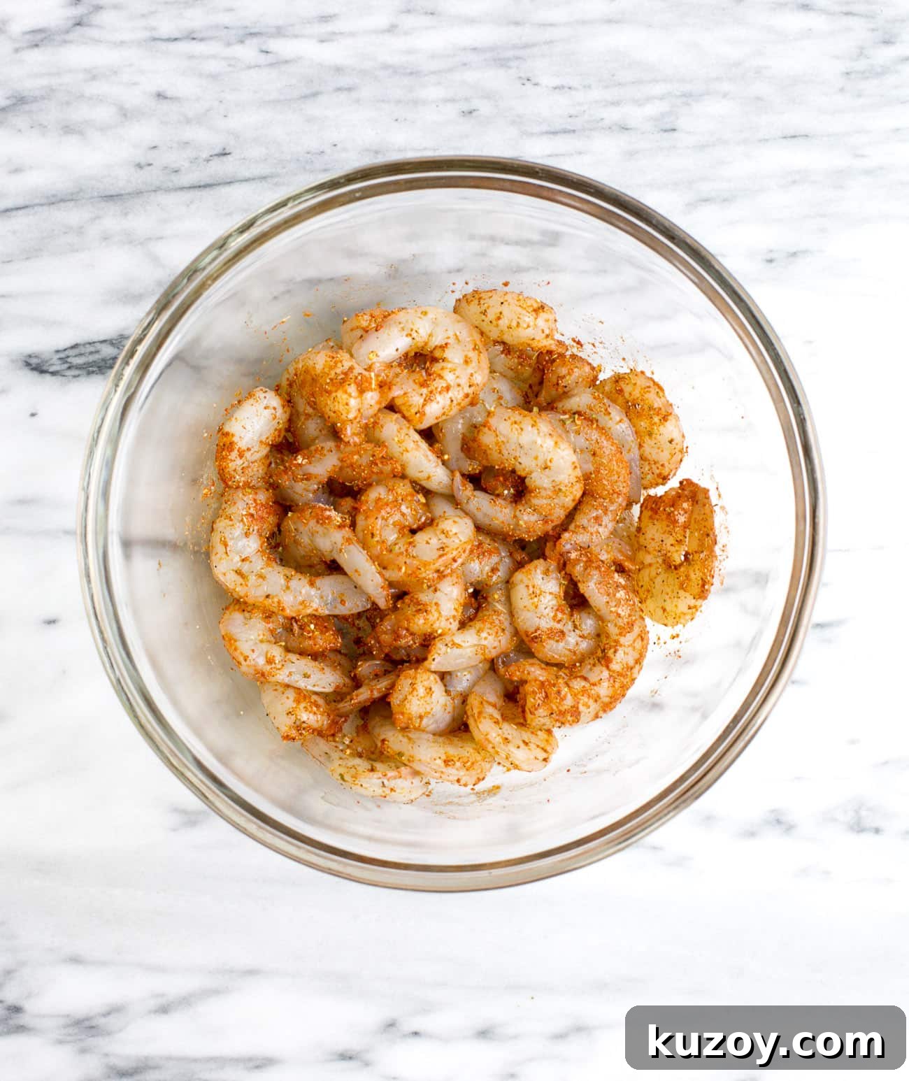 Spicy Cajun Shrimp Skewers with Garlic Butter Dip 3 seasoned raw shrimp in a glass bowl
