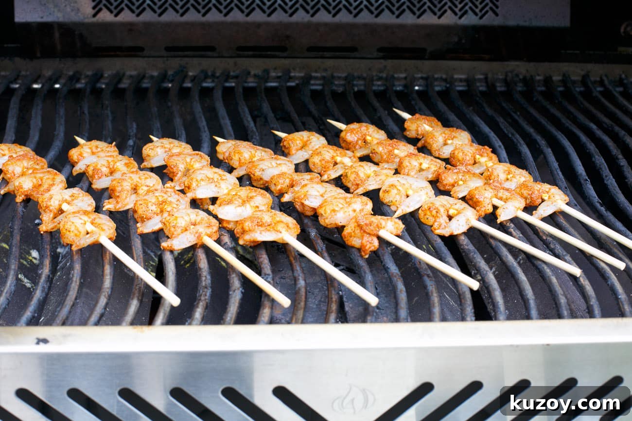Spicy Cajun Shrimp Skewers with Garlic Butter Dip 5 shrimp kabobs in a grill.