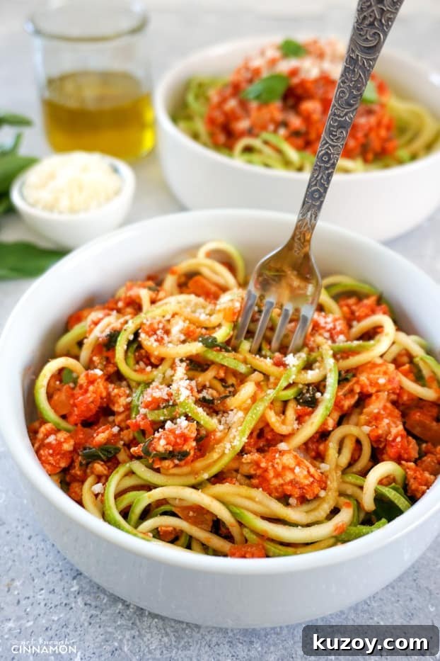 Turkey Bolognese with Zucchini Noodles — Quick Weeknight Dinner 7 A bowl of turkey bolognese with zucchini pasta with a fork about to dig in.