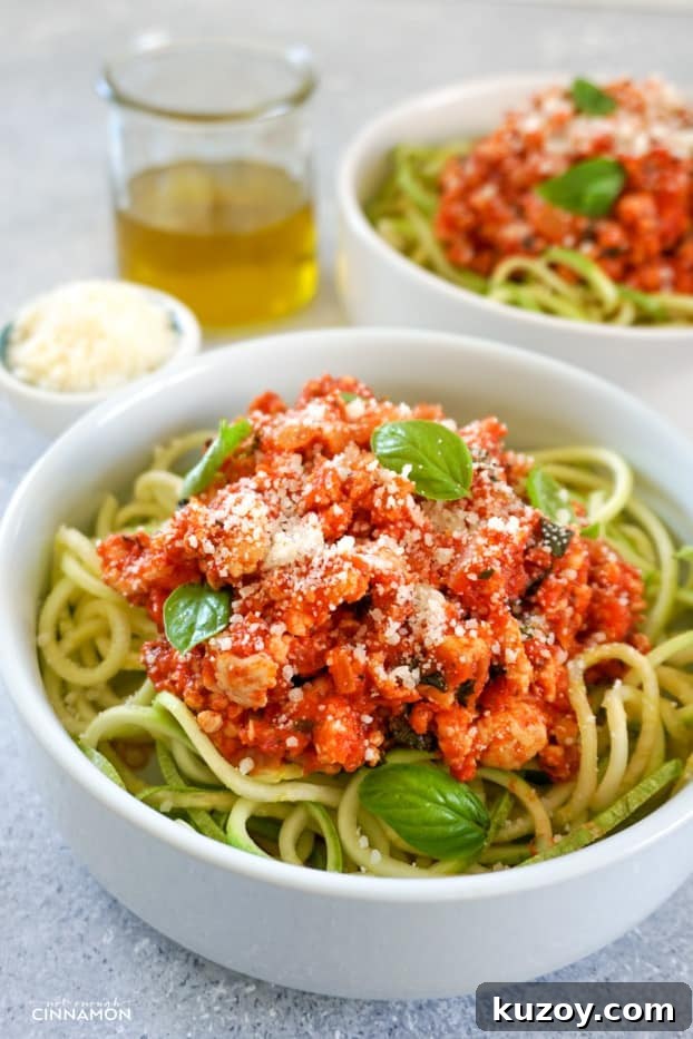 Turkey Bolognese with Zucchini Noodles — Quick Weeknight Dinner 8 Two bowl of turkey bolognese sauce over zucchini pasta, sprinkled with grated parmesan, in two shallow round plates
