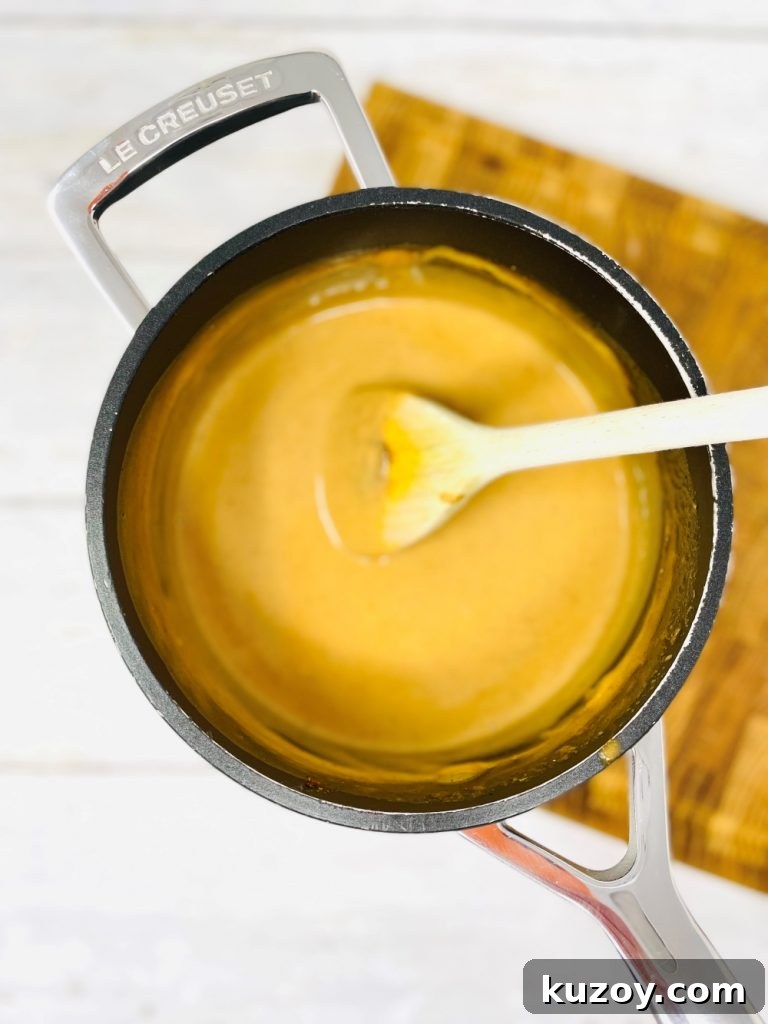 black le creuset pan filled with homemade satay stir fry sauce 
