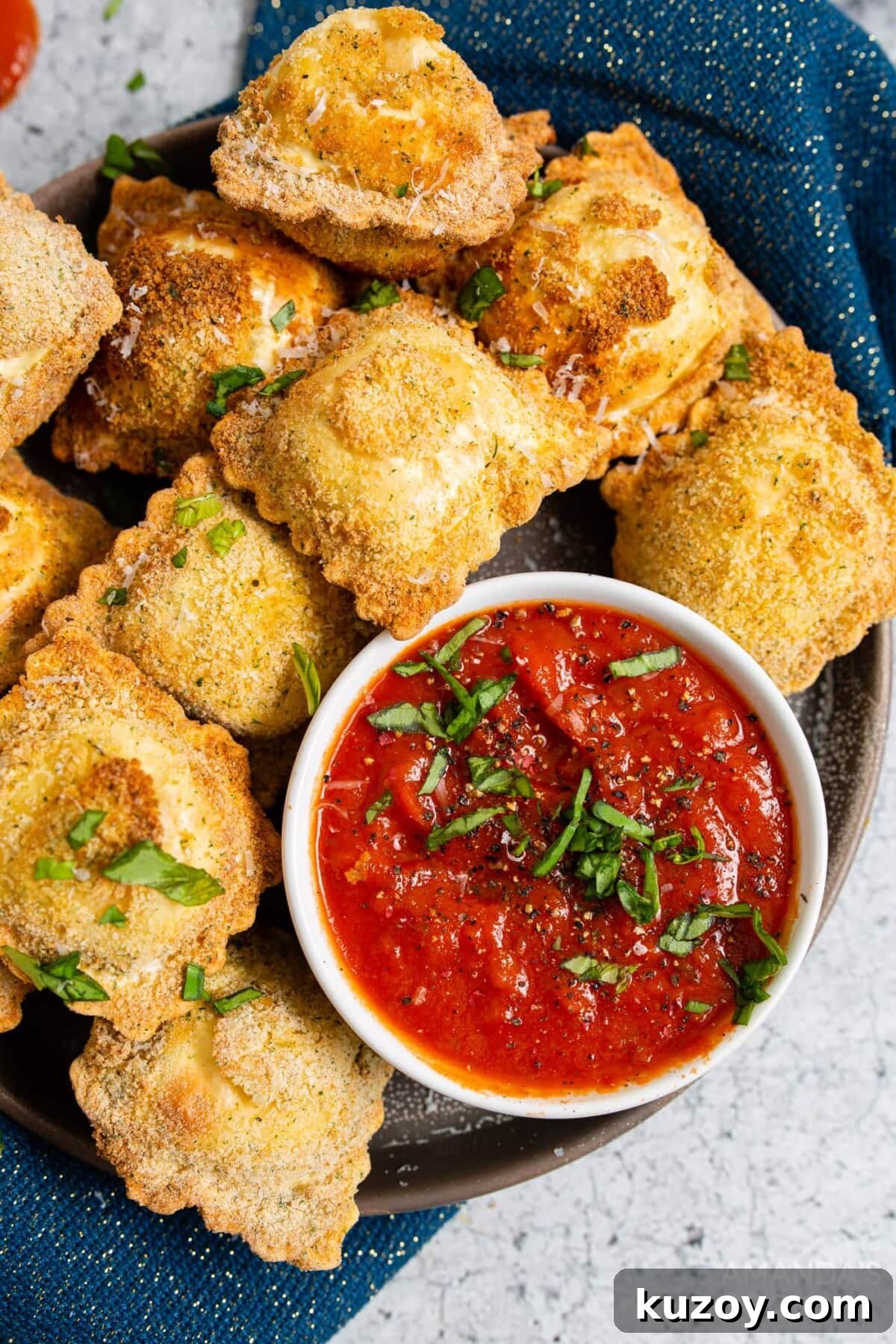 Crispy Air Fryer Ravioli with Marinara Dipping Sauce 2 air fryer ravioli on a plate with marinara