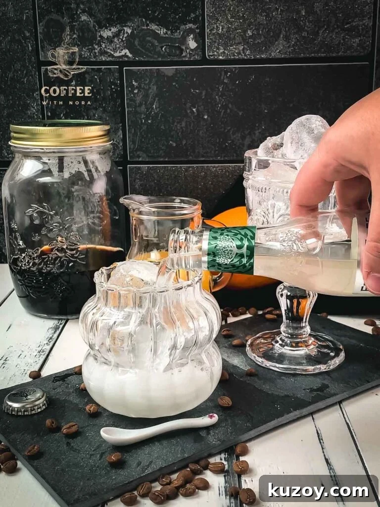 Ginger Cold Brew Recipe: Refreshing Iced Ginger Coffee 4 Pouring ginger beer into a glass filled with cubed ice.