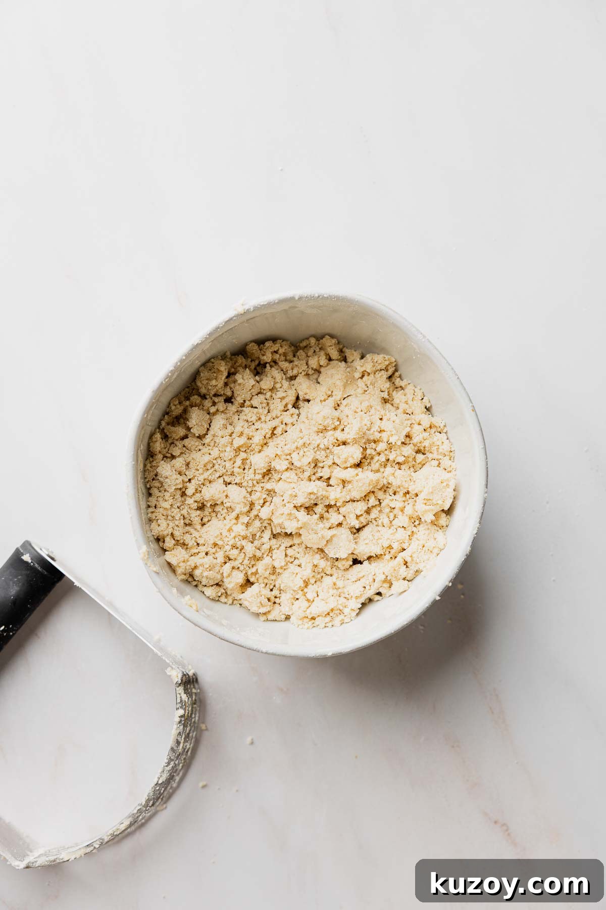 Gluten-Free Blueberry Muffins with Crunchy Streusel Topping 5 Streusel topping in small bowl next to pastry knife.