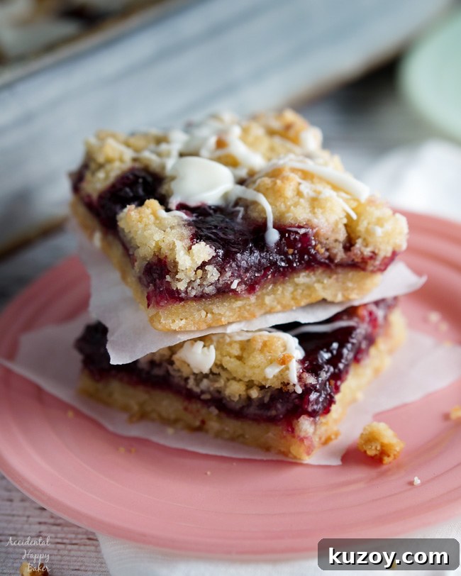 Raspberry and White Chocolate Shortbread Bars Recipe 2 Two Raspberry White Chocolate Shortbread bars sitting on a plate