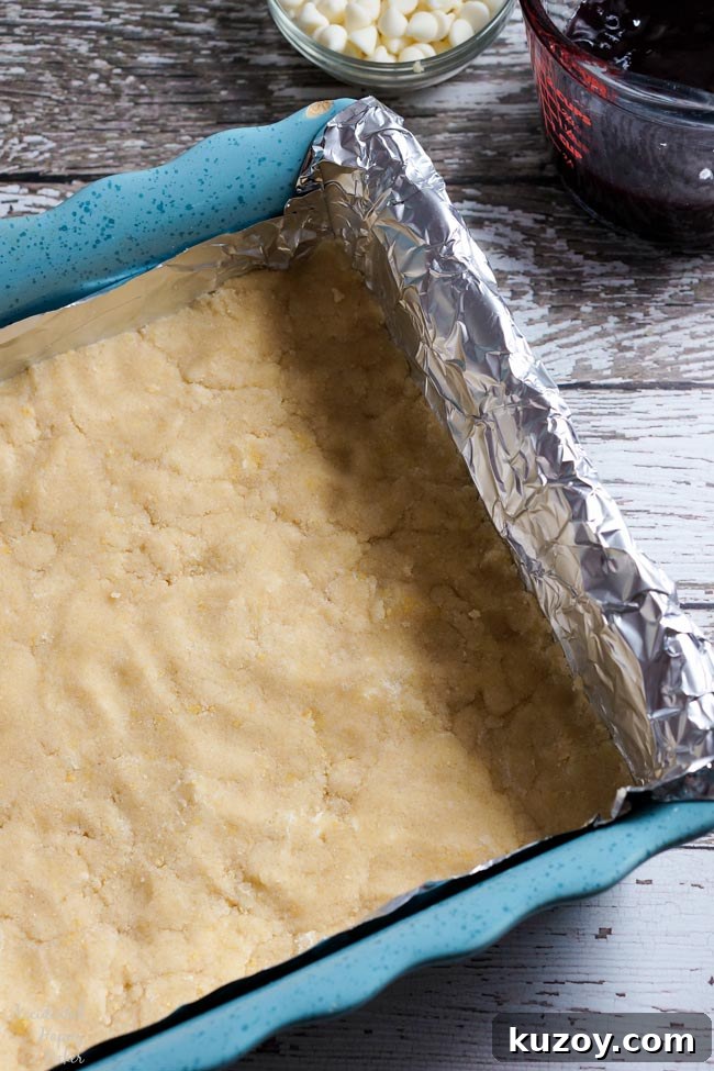 Raspberry and White Chocolate Shortbread Bars Recipe 3 First a layer of shortbread dough is pressed into a foil lined pan.