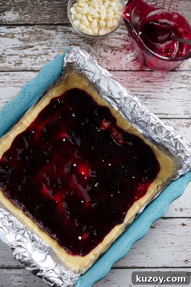 Raspberry and White Chocolate Shortbread Bars Recipe 4 Next spread the raspberry jam over the shortbread cookie dough.