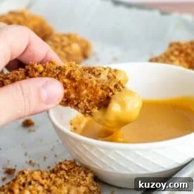 Sourdough Chicken tenders being dipped in sauce.