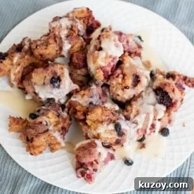 A plate of berry donut fritters, small donut-hole sized fritters made with berries and glazed.