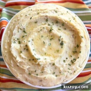 Cream Cheese Crock-Pot Mashed Potatoes — Slow Cooker Recipe 13 Creamy crock-pot mashed potatoes with cream cheese and sour cream in a serving bowl with pools of butter, and chives on top.