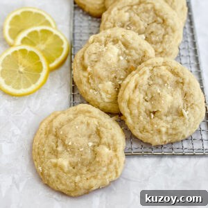 lemon coconut white chocolate cookies with some sliced lemons on the side.