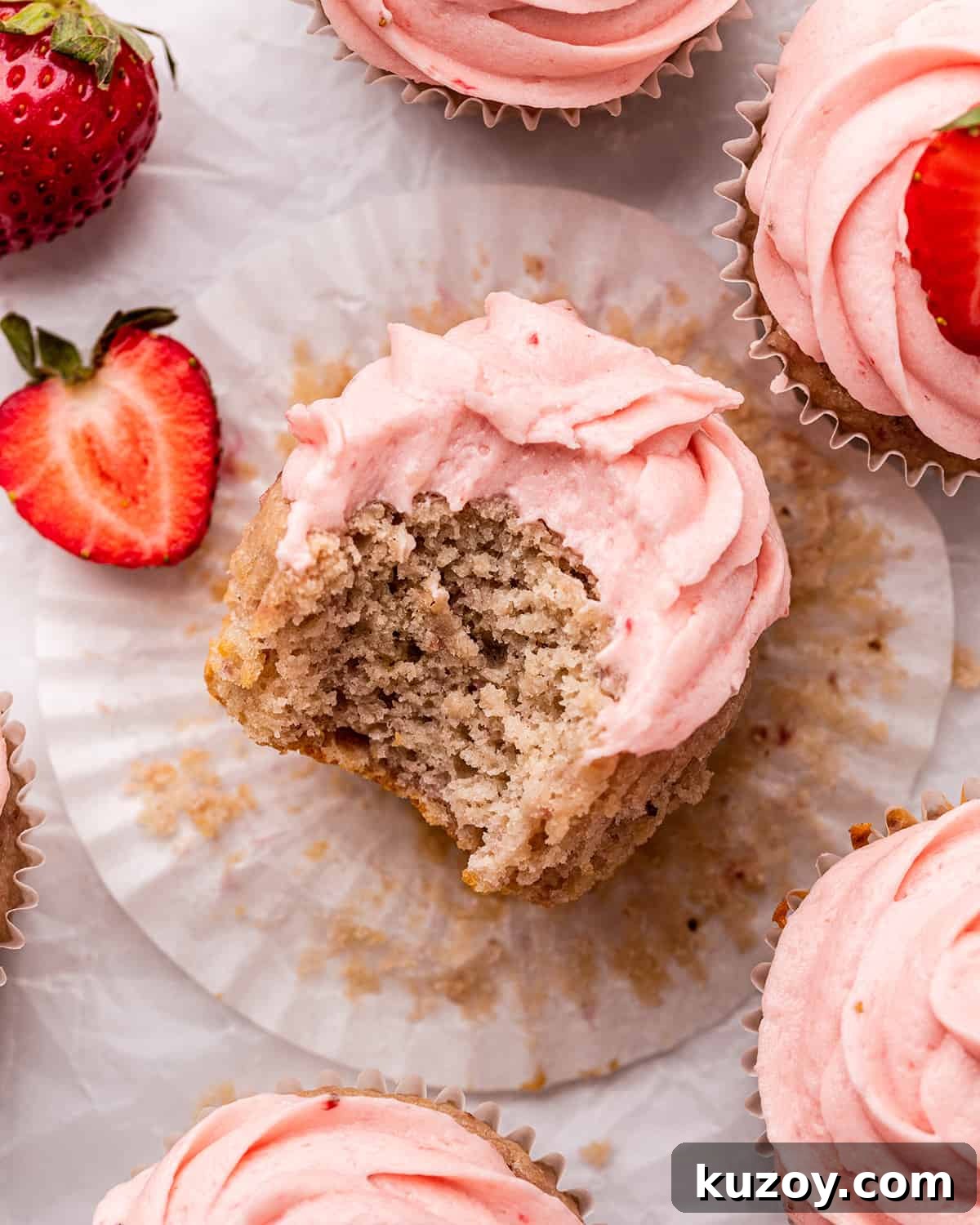 a frosted Strawberry Cupcake with a bite taken out of it