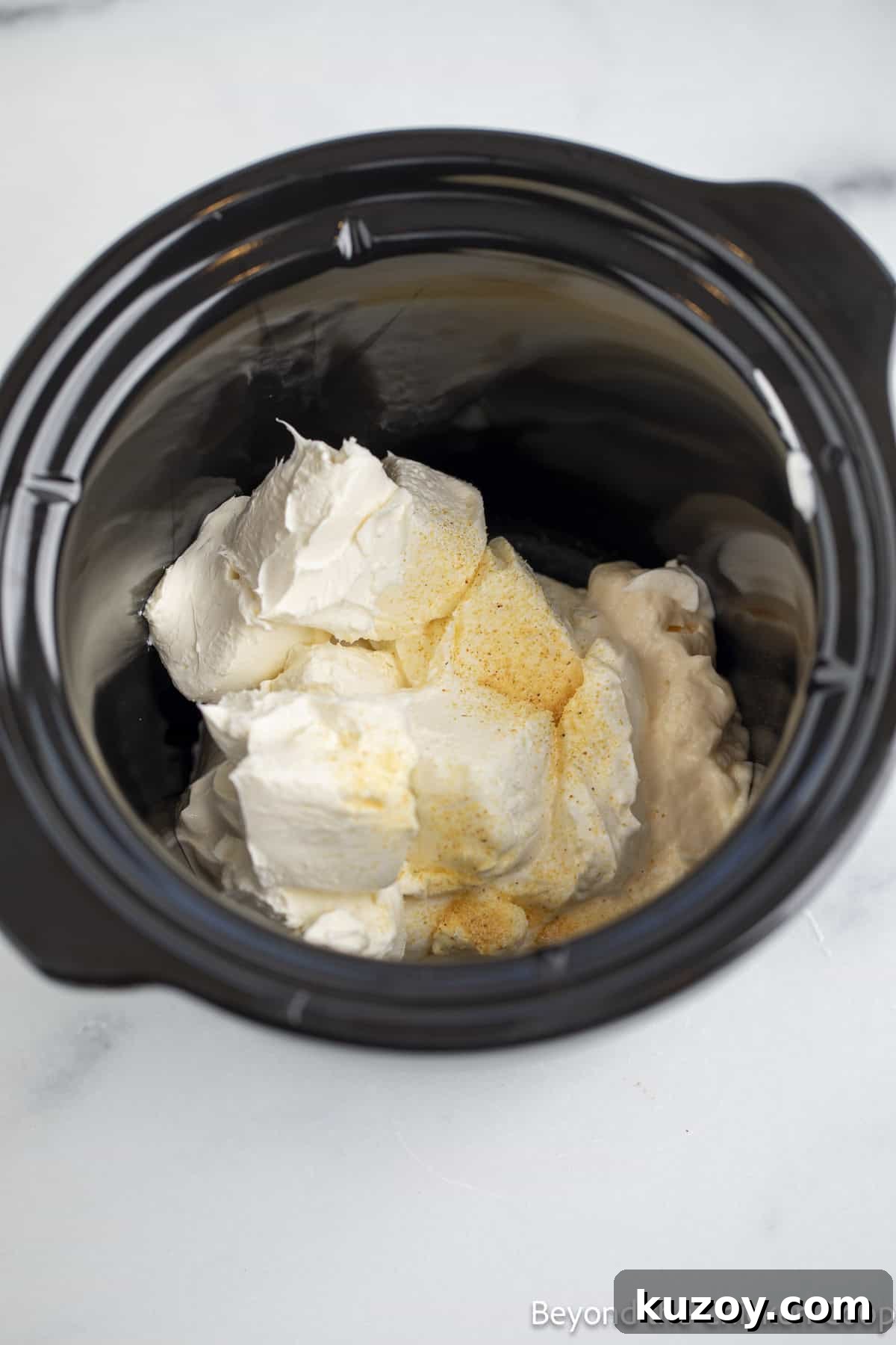 Creamy Spinach and Artichoke Dip Recipe for Entertaining 4 Cream cheese and seasoning in a crock pot.