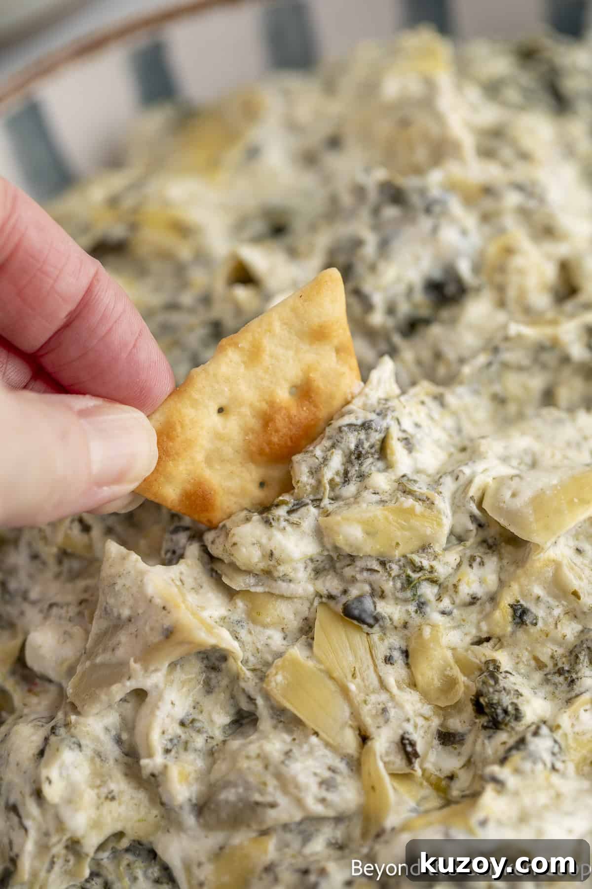 Creamy Spinach and Artichoke Dip Recipe for Entertaining 8 Scooping up some creamy dip with a pita chip.