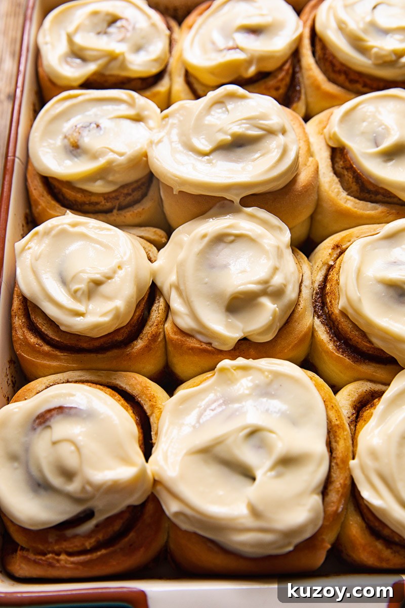 Maple Cream Cheese Cinnamon Rolls with Sticky Glaze 2 cinnamon rolls with icing in a pan