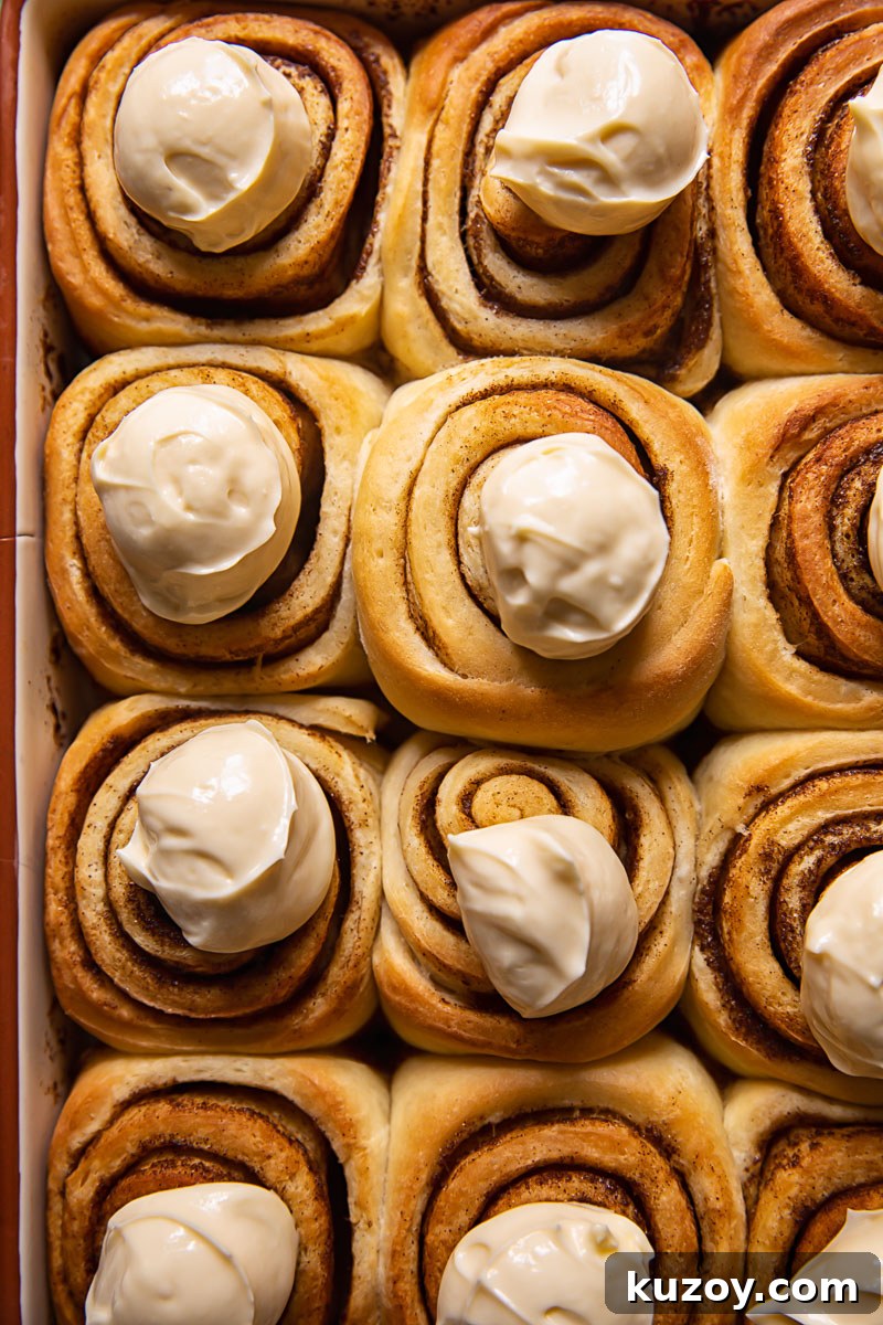 Maple Cream Cheese Cinnamon Rolls with Sticky Glaze 4 cinnamon rolls with dollops of icing on top