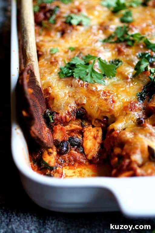 Mexican Chicken Tortilla Casserole in white baking dish with some removed.