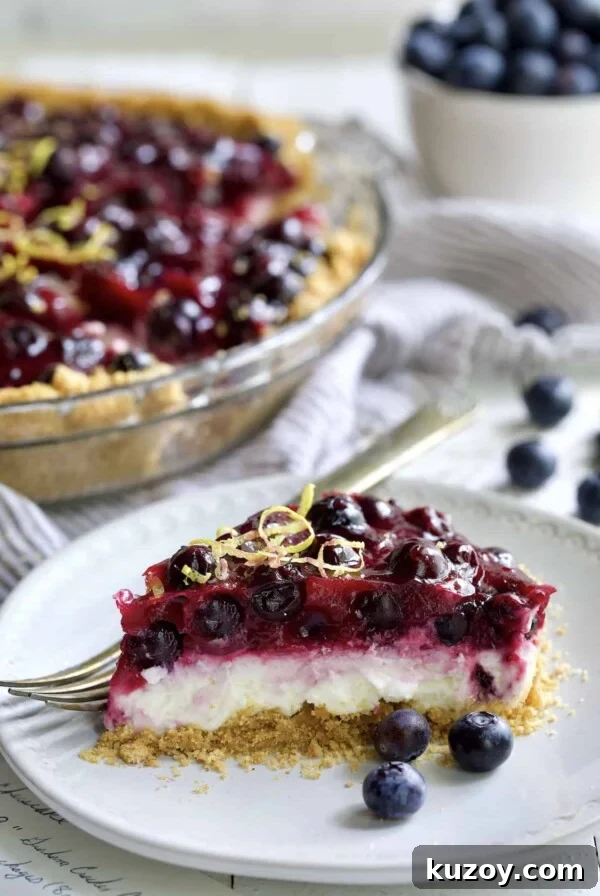 Photo of a slice of Blueberry Cream Cheese Pie on a white plate.