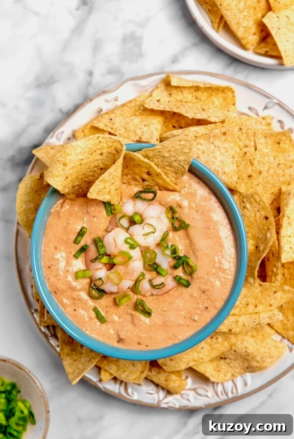 Creamy Shrimp Salsa Dip in bright blue bowl on platter with tortilla chips.