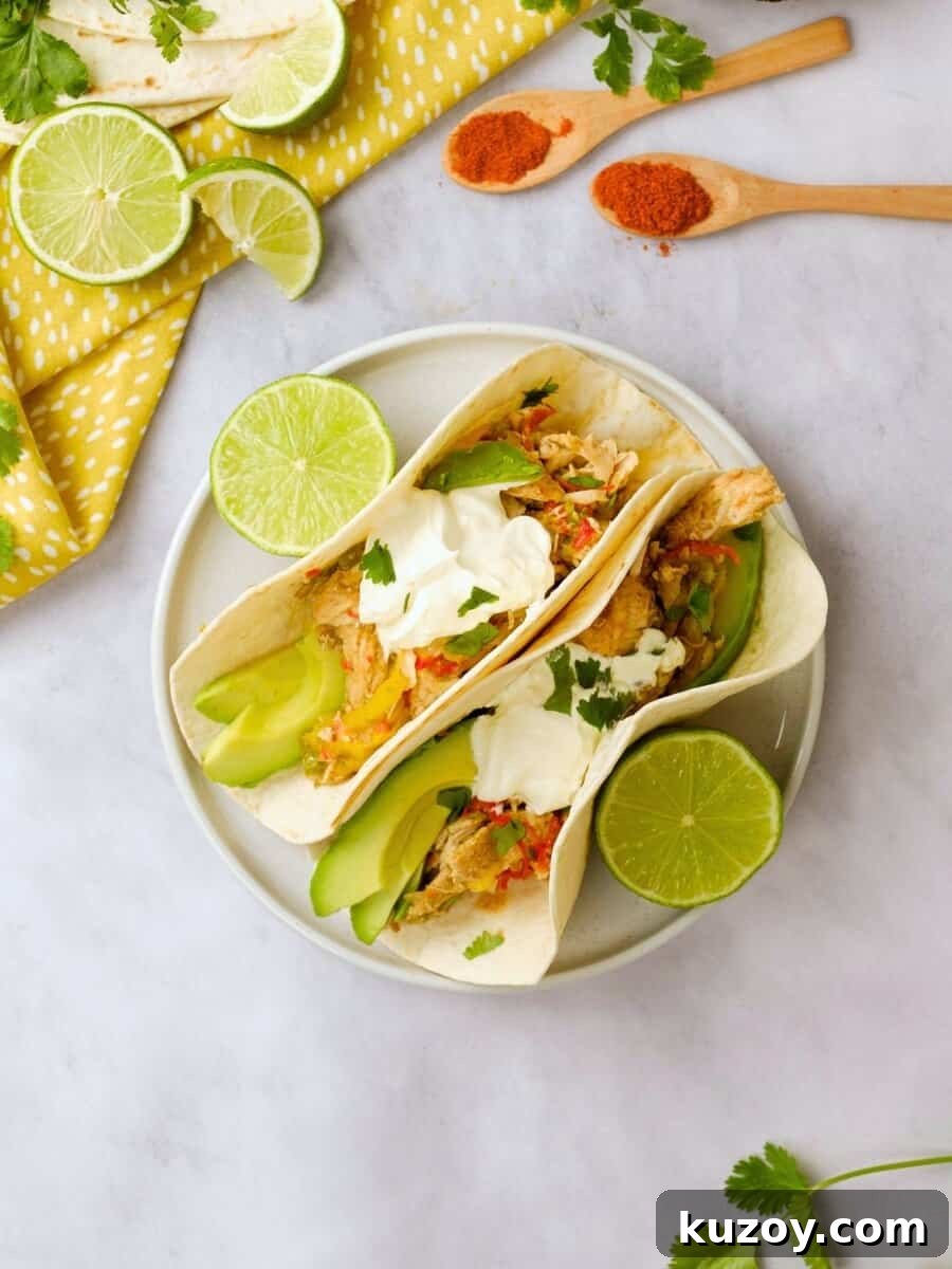 Instant Pot chicken Fajitas Assembled fajitas made with Instant Pot Chicken Fajita mixture on plate with fresh limes and cilantro in background.