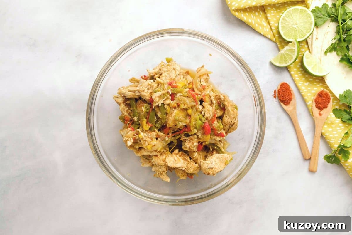 Instapot Fajitas Chicken and pepper mixture in mixing bowl with lime zest.