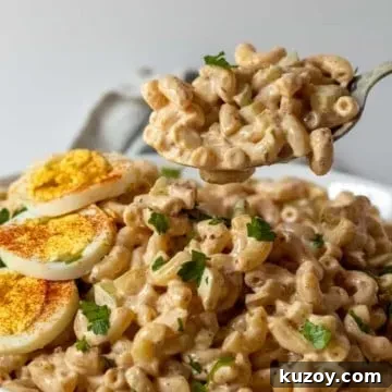 In white serving bowl garnished with hardboiled egg and spoonful closeup.