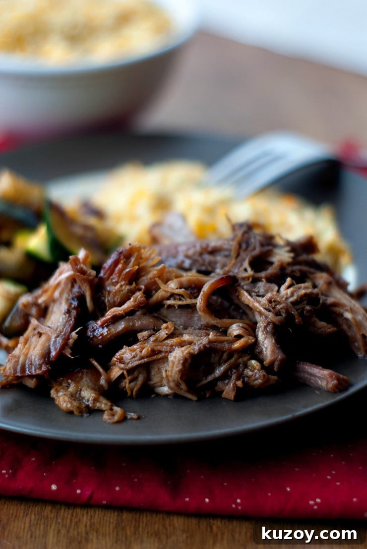 Slow Cooker Blackberry BBQ Pulled Pork on a black plate.