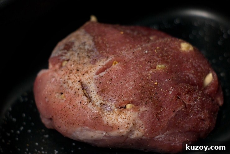 Seasoned Pork Meat with garlic on a black skillet.
