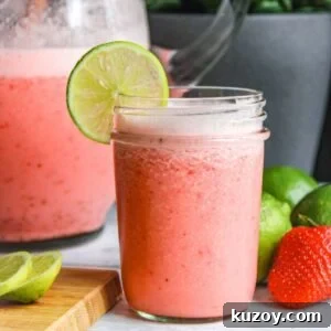 Glass of Brazilian limeade with strawberries.