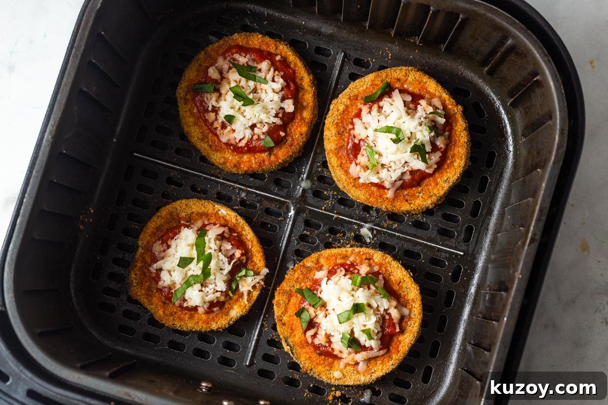 Crispy Air Fryer Eggplant Parmesan Recipe 11 adding mainara sauce and mozzarella cheese to the cooked eggplant.