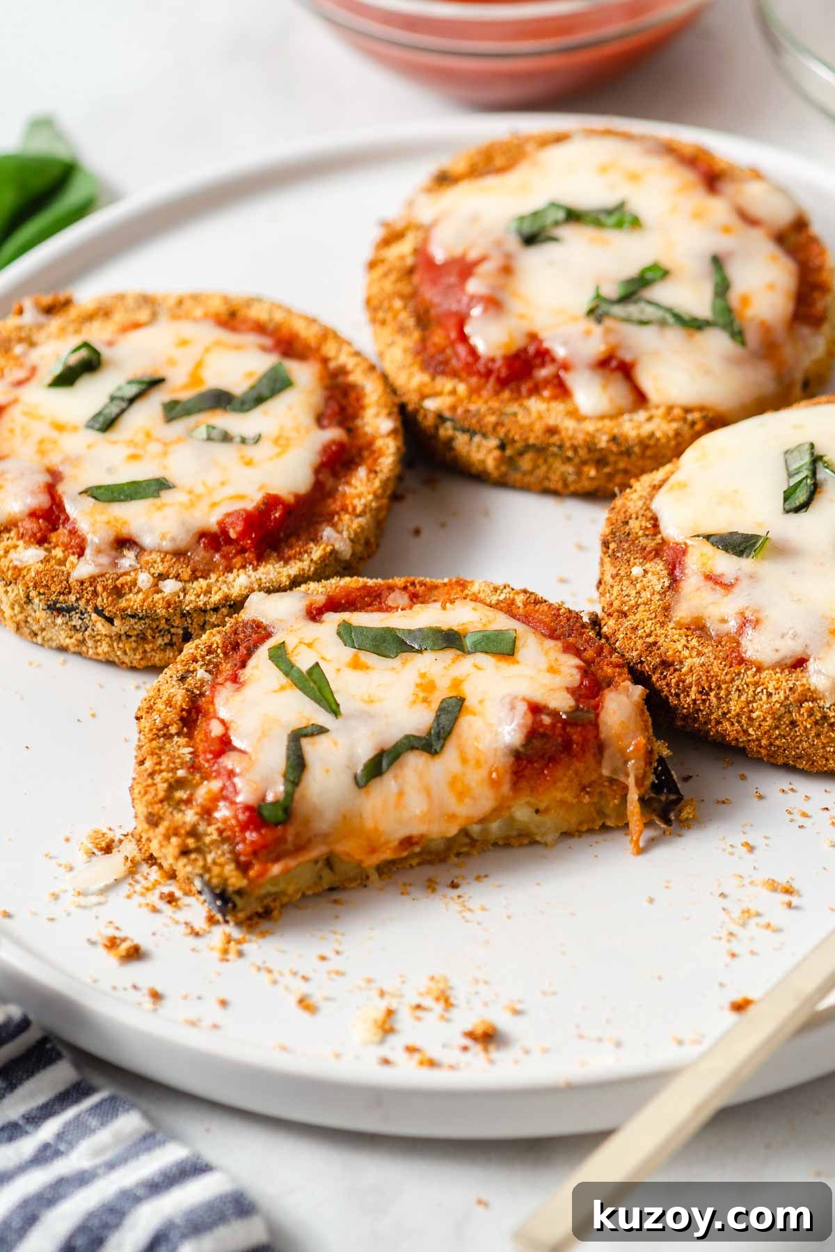 Crispy Air Fryer Eggplant Parmesan Recipe 14 air fried eggplant parmesan on a plate with cheese oozing out.