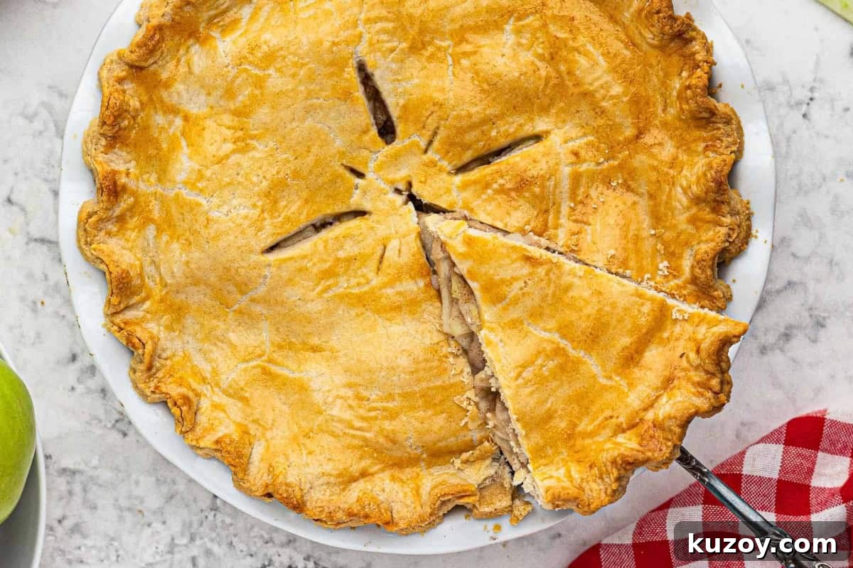 Classic Homemade Apple Pie Recipe for Perfect Crust and Filling 3 overhead view of a pie server removing a slice of apple pie from a pie dish.