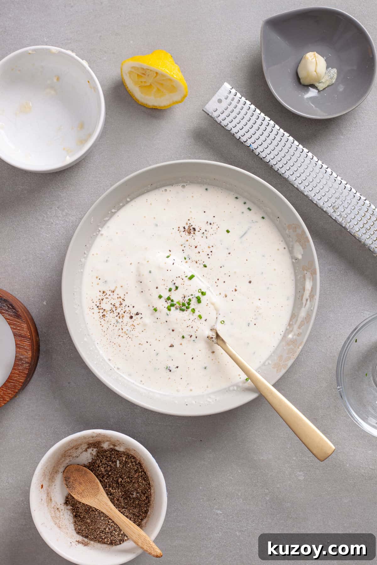 A small mixing bowl with horseradish aioli stirred until smooth and topped with chopped fresh chives.