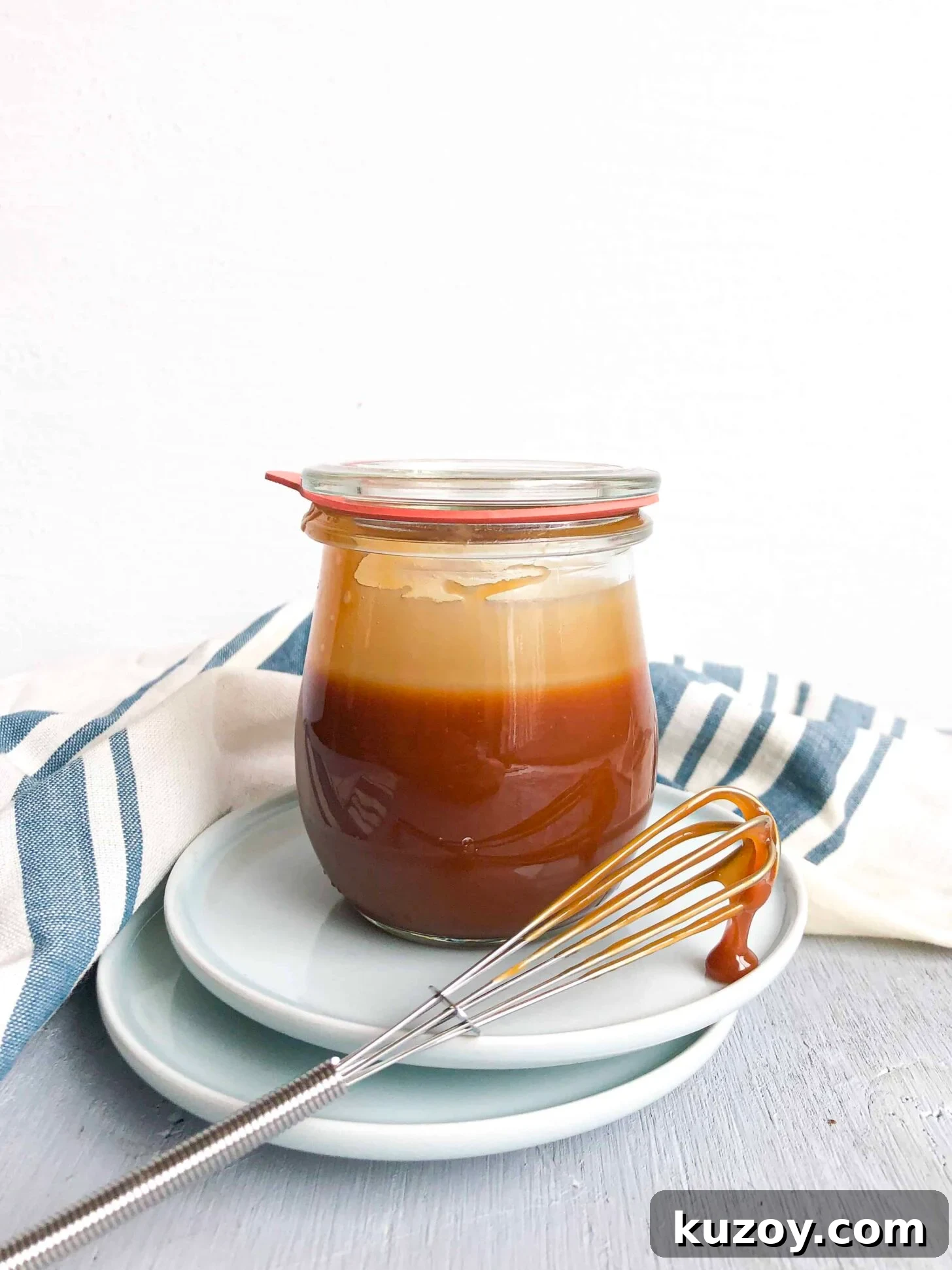 A jar of caramel sauce with a whisk
