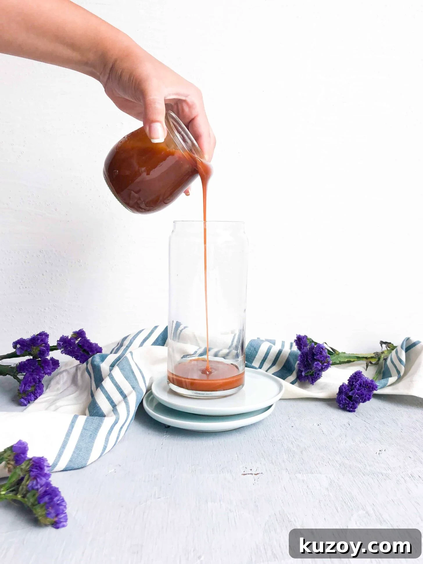 Homemade caramel sauce drizzling into a glass