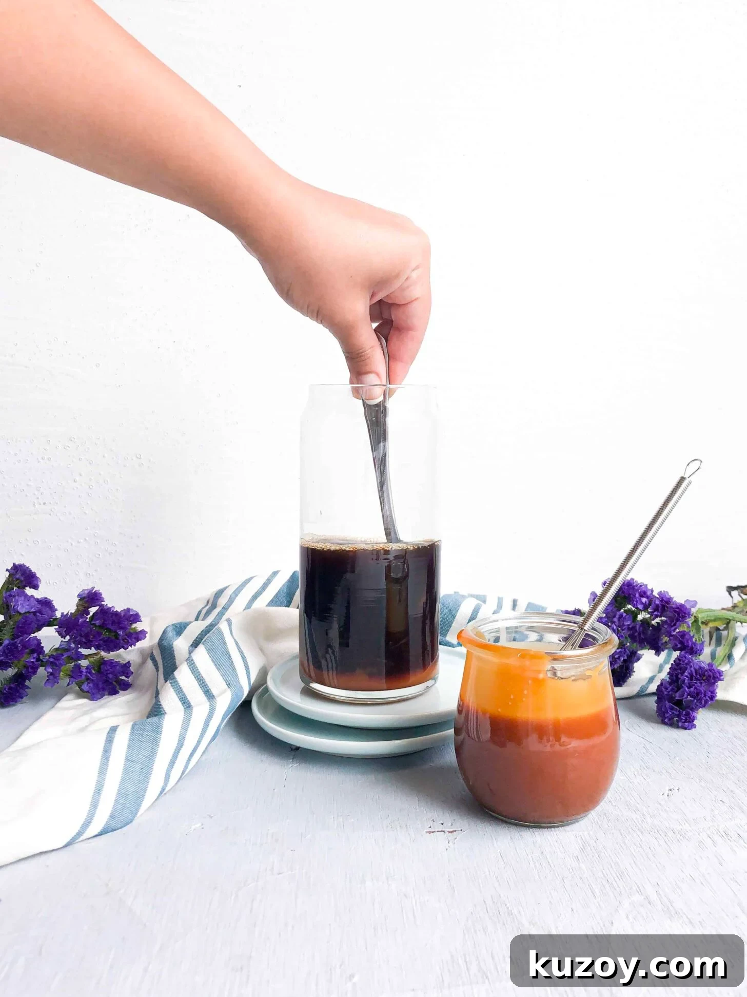Homemade caramel sauce getting mixed into black coffee