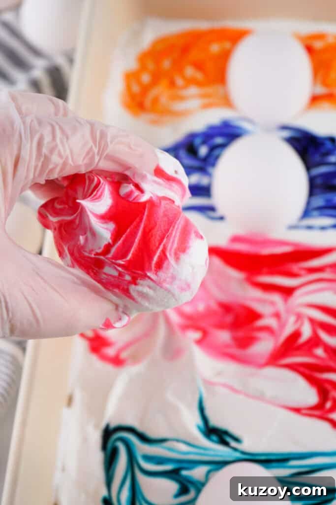 Vibrant Easter Eggs Dyed with Cool Whip: Step-by-Step Guide 7 hand holding a cool whip dyed easter egg