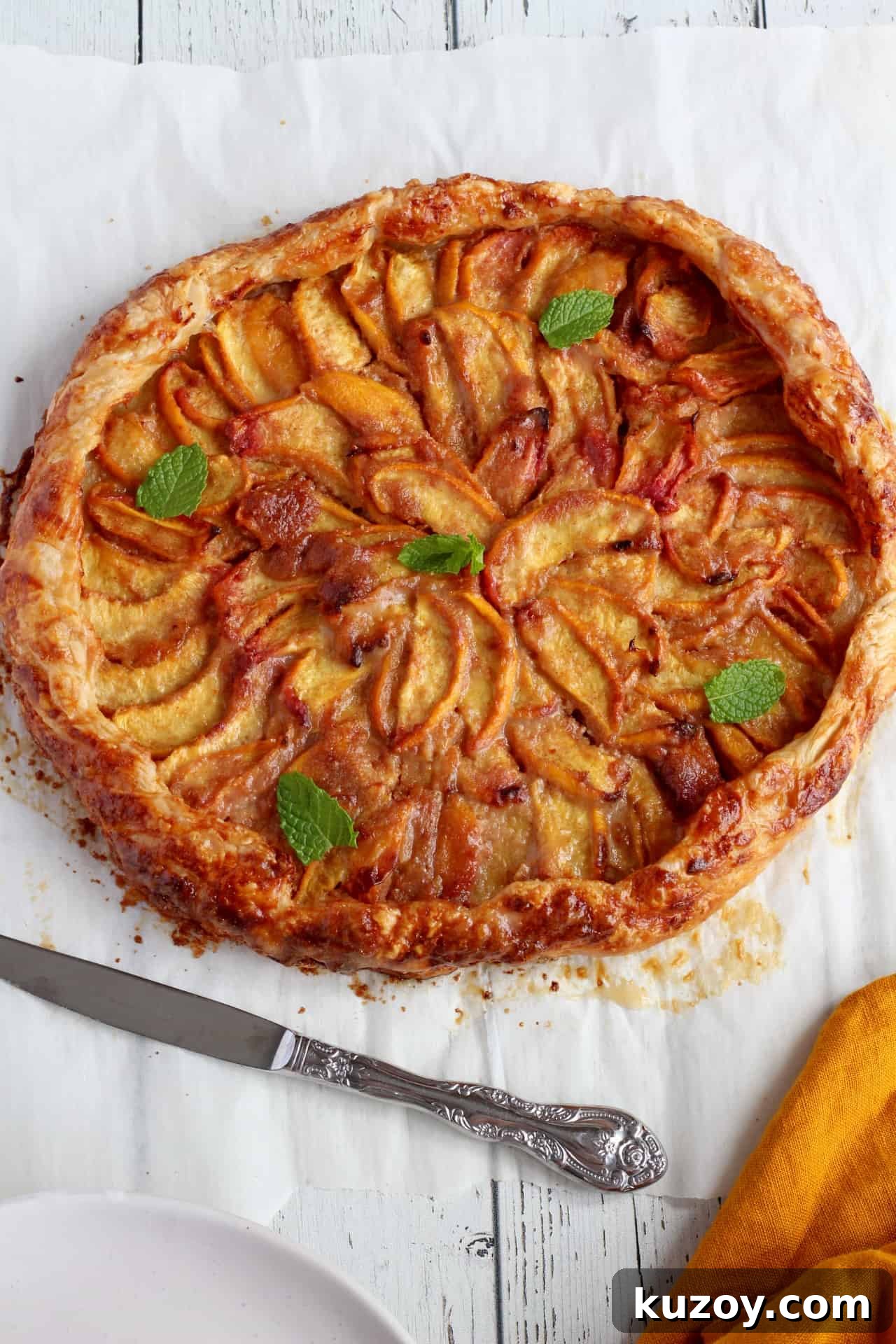 Peach Galette with Flaky Puff Pastry: Simple Summer Dessert 2 round peach galette sprinkled with mint leaves